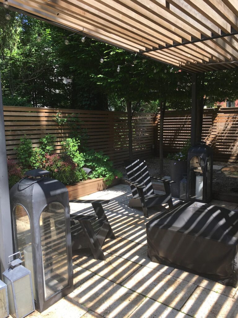 A garden with benches and trees in the background.