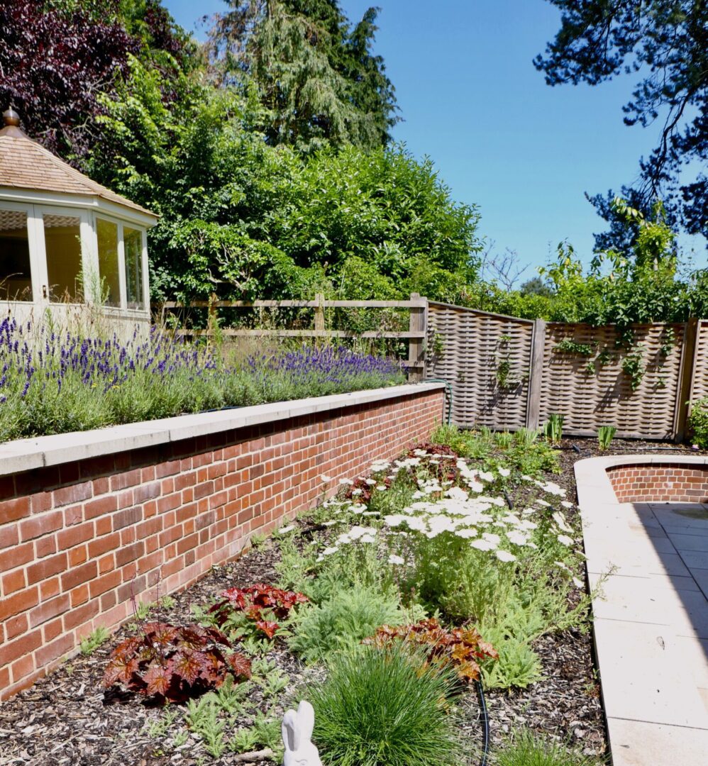 A garden with flowers and trees in the background.