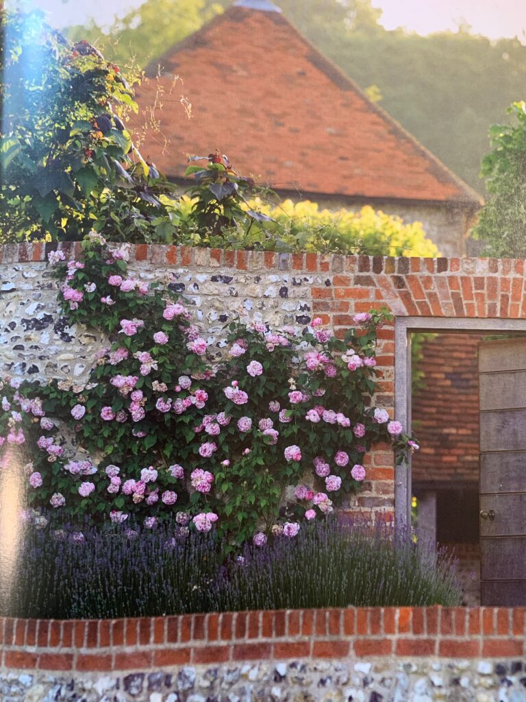 A painting of flowers in front of a brick wall.