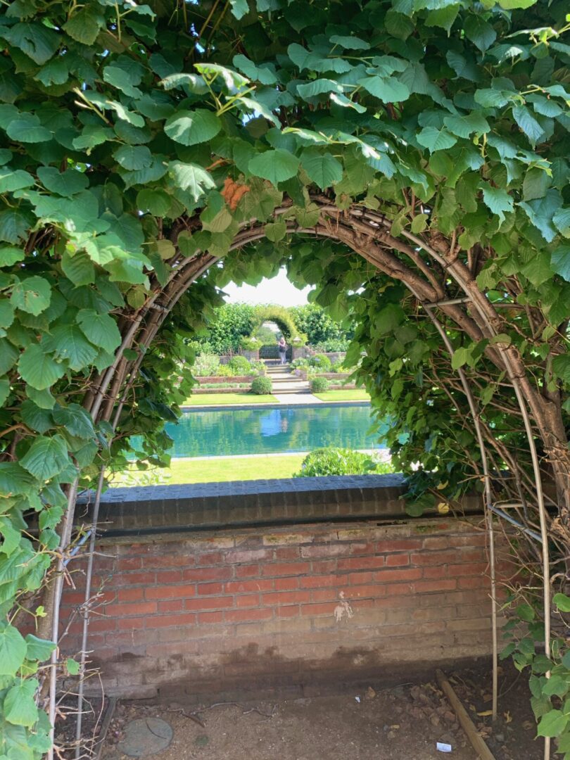 A view of a garden from inside an arch.