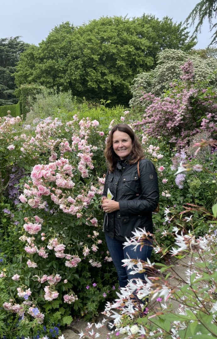 A woman standing in front of some bushes