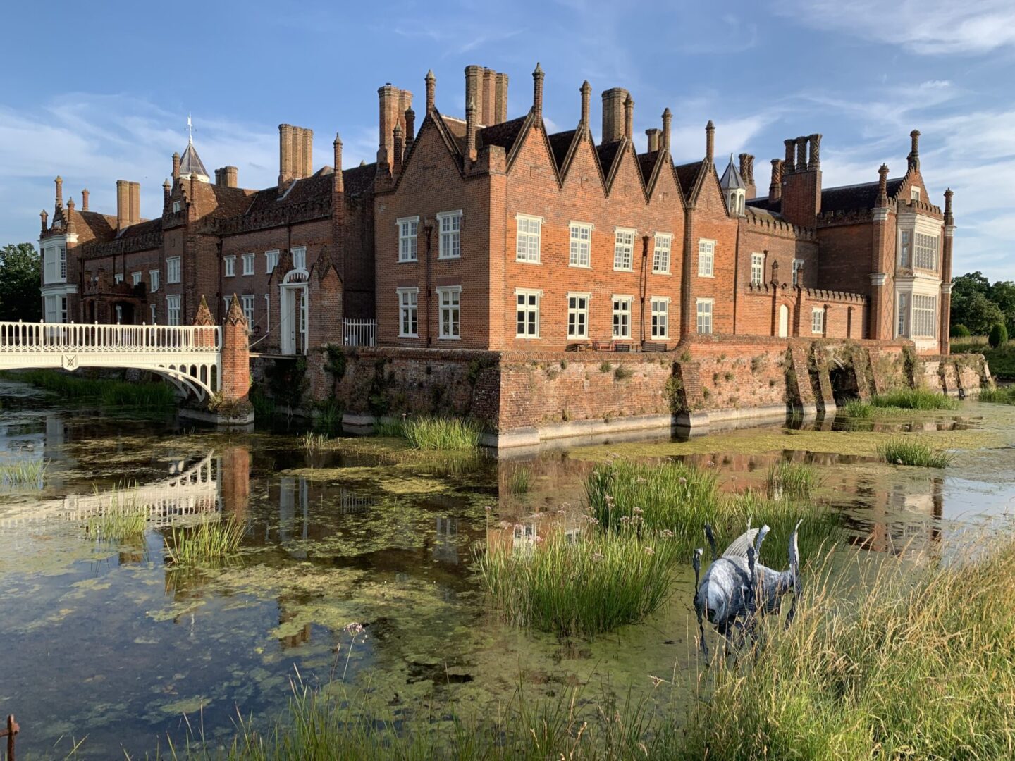 A large brick building with water and grass around it.