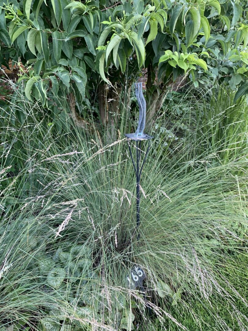 A metal pole in the middle of some bushes