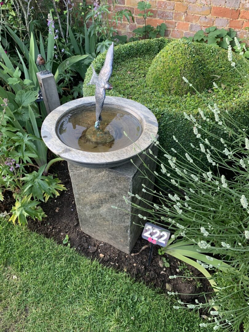 A fountain in the middle of some bushes