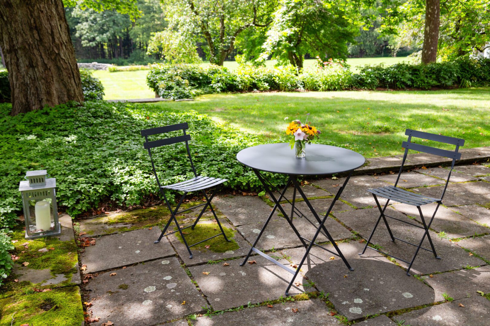 A table and chairs set up in the middle of a garden.