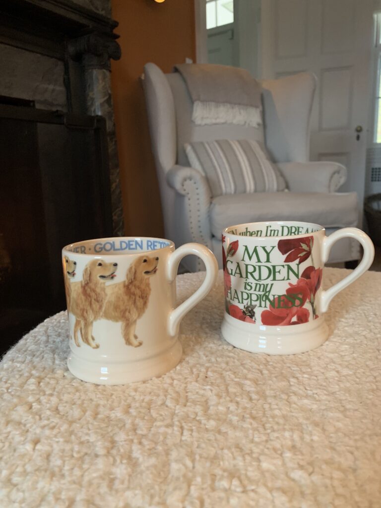 Two mugs sitting on a table next to each other.