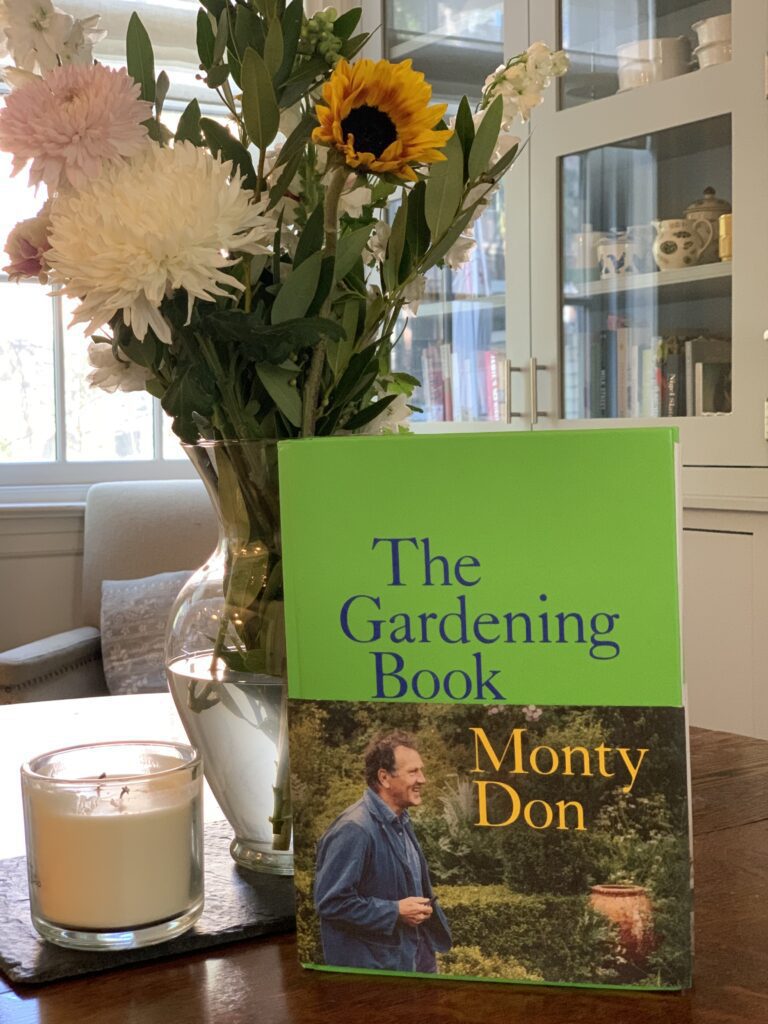 A book sitting on top of a table next to flowers.