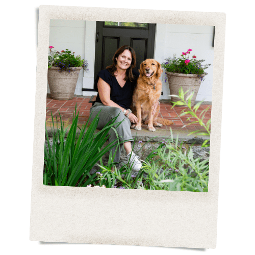 A woman and her dog sitting on steps outside.