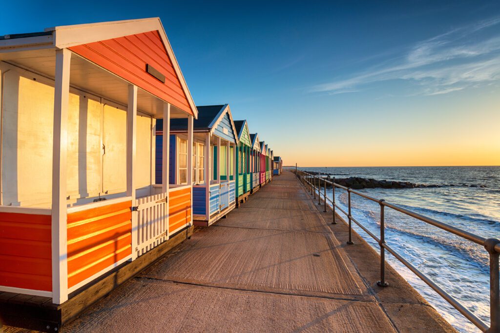 A row of colorful beach huts on the boardwalk.