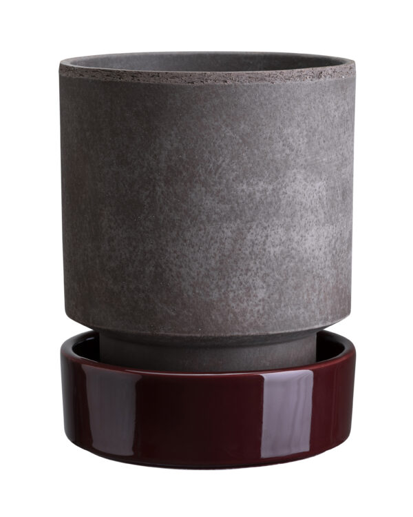 A gray and red vase sitting on top of a wooden stand.