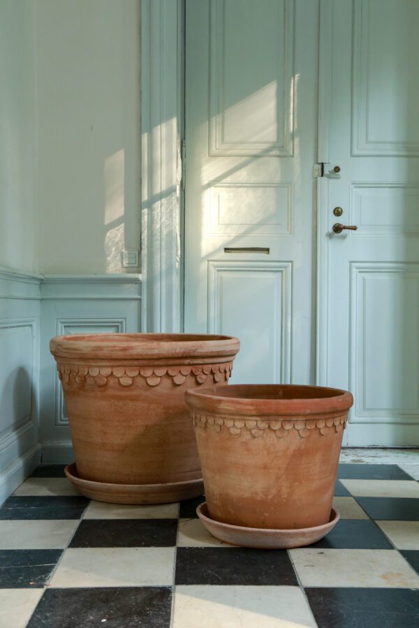 Two large pots are sitting in front of a door.