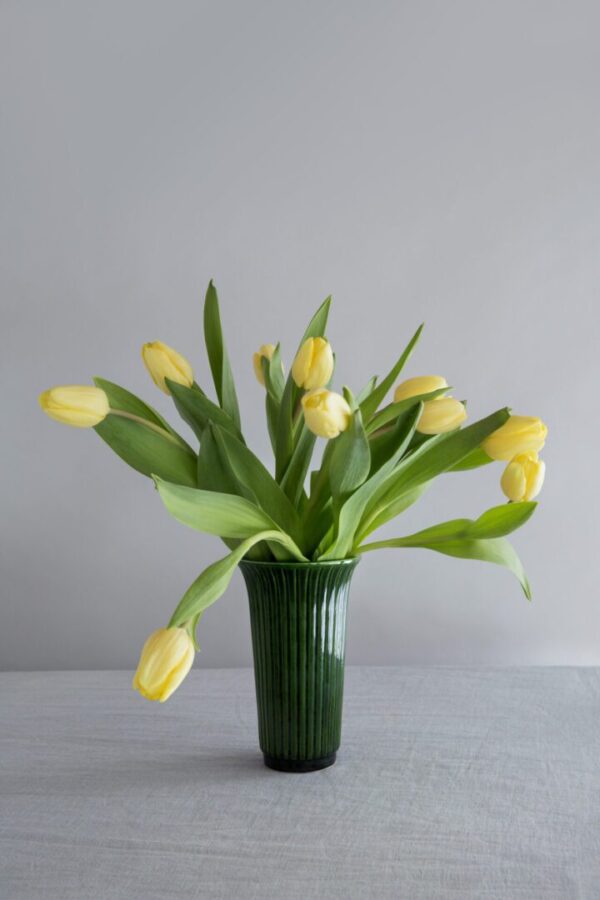 A vase filled with yellow flowers on top of a table.