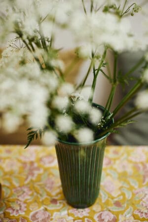 White flowers in a green vase.