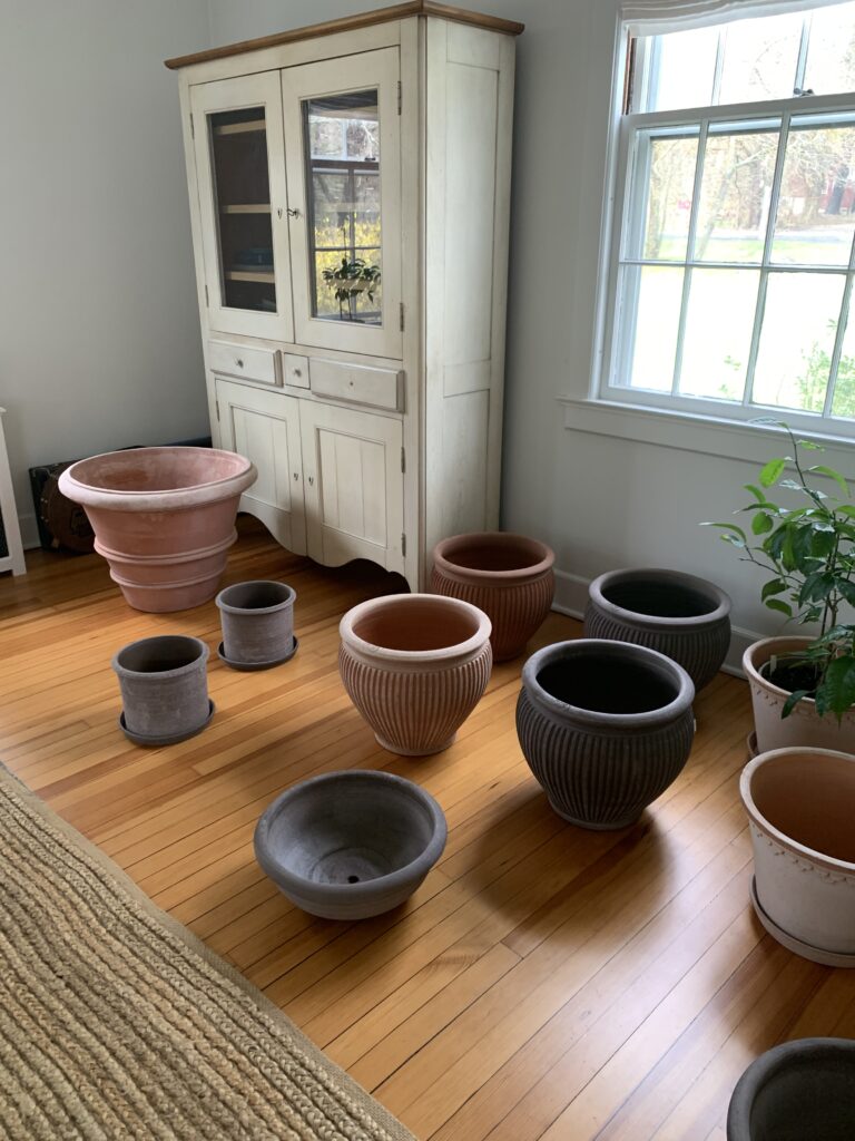 A room with many different sized pots on the floor