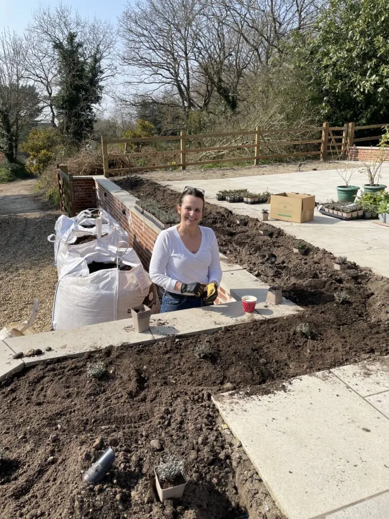 A woman sitting on the ground in front of a pile of dirt.