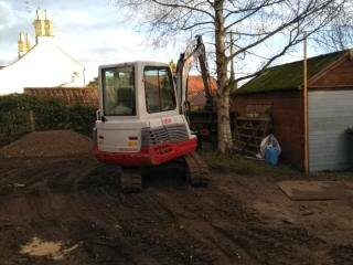 A small white and red tractor parked in the dirt.