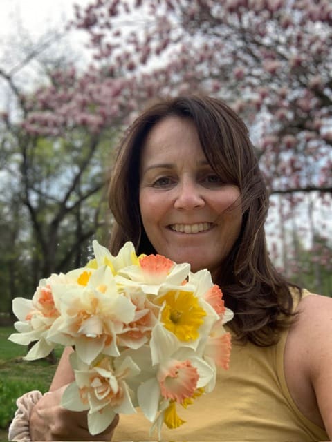 Woman holding bouquet of flowers outdoors.